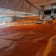 Kruipruimte met oranje thermokussens netjes aangebracht tegen de onderzijde van de vloer in Tilburg